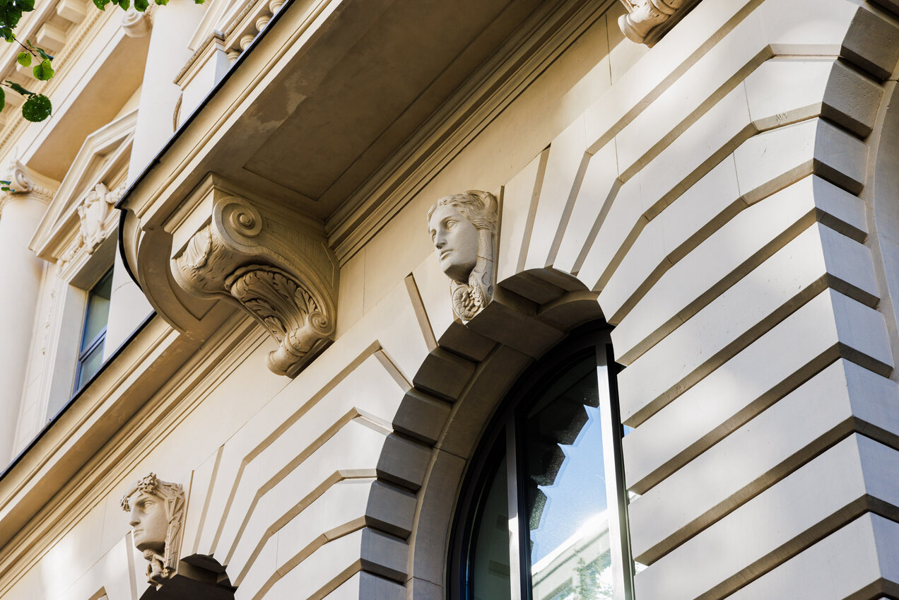 details of a building facade, window arcs with busts on the top