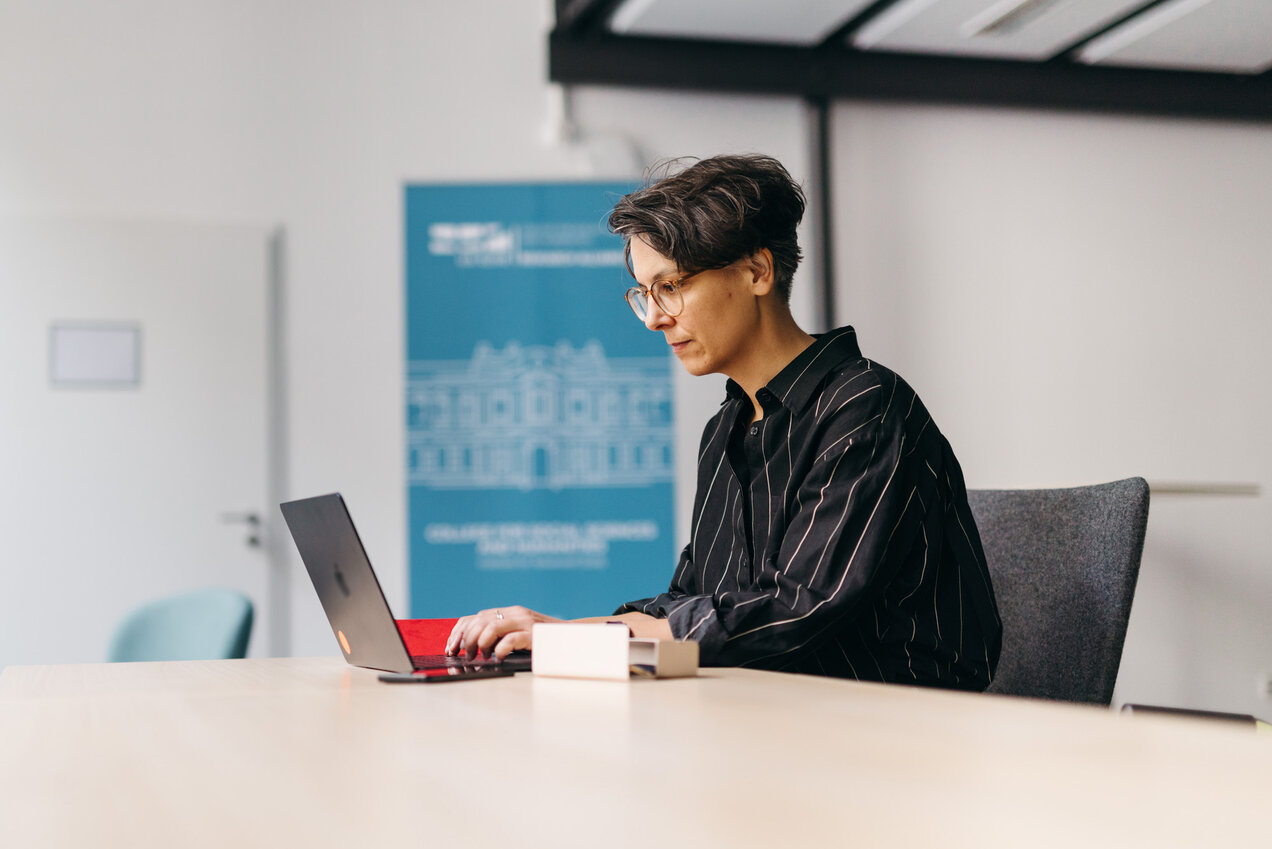 professor Nadim sitting at a desk, working with a laptop